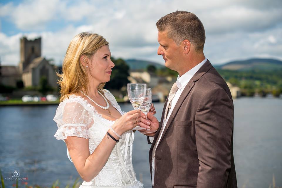 Bride and groom raising their glasses in a toast at a chic city in port laoise wedding.