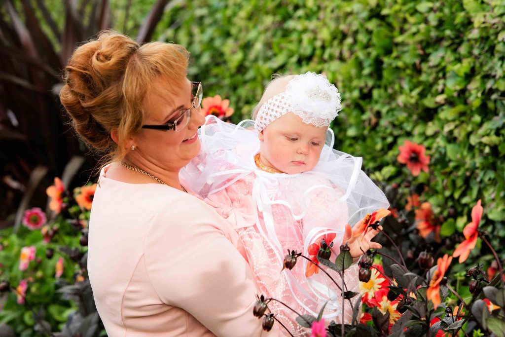 Cherished moment as the godparents pose with the baby, celebrating their role in the child's spiritual journey.