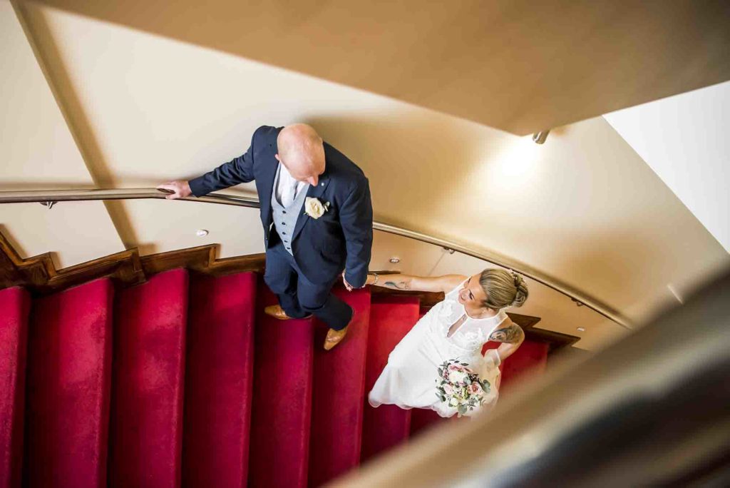 Whispers of love exchanged as the couple walks down a tree-lined path.