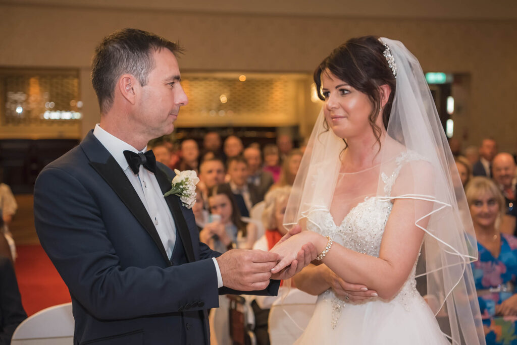 Intimate moment as the couple exchanges heartfelt vows under a floral arch.