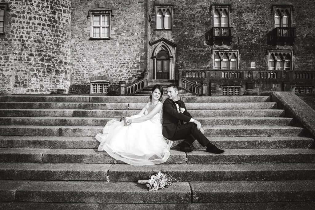 Bride's flowing veil and groom's suit in motion as they walk joyfully.