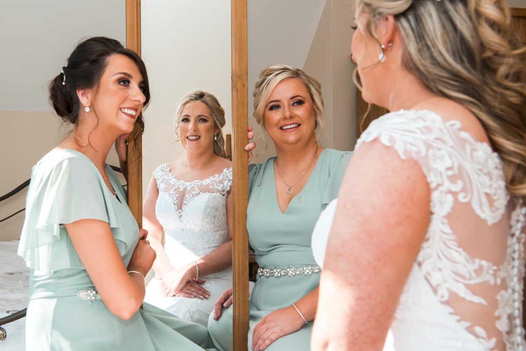 Bride's reflection in a vintage mirror as she puts on her final touches.