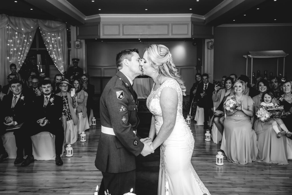Happy bride and groom sharing a kiss during sunset ceremony.