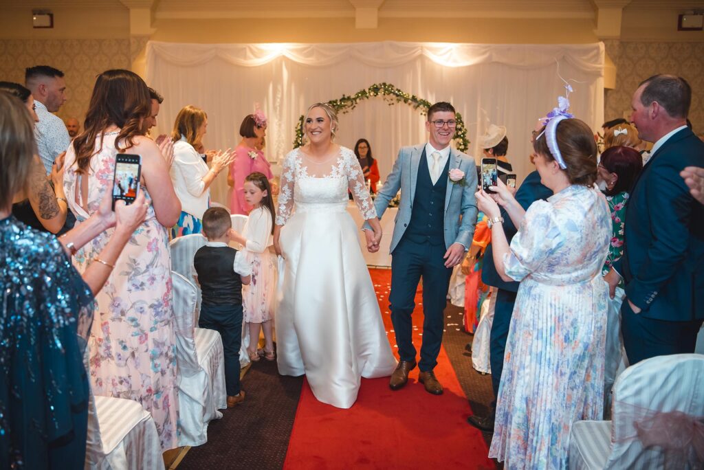 Casual and carefree – bride and groom walking with smiles on their wedding day.