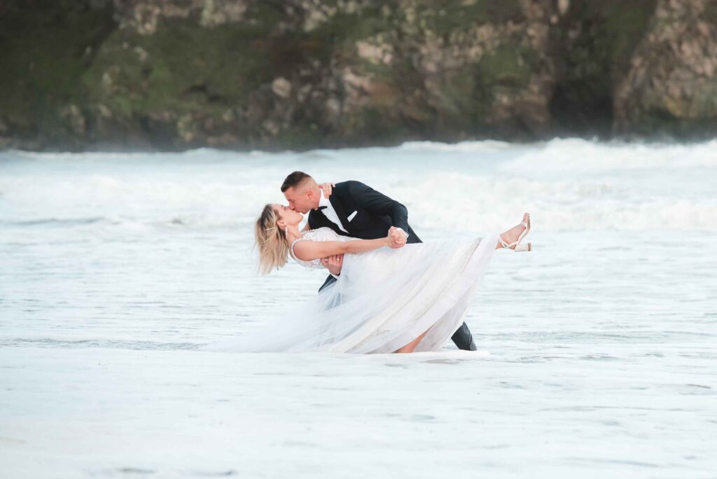 Charming Bride and Groom in a beautiful and coordinated pose during unexpected tide. Not really.